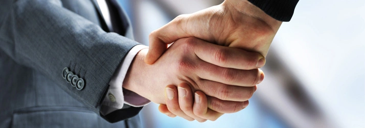 Chiropractic Traverse City MI Other Insurance Hero Handshake where one of the people is dressed in a formal men's suit.